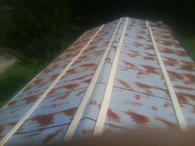 Rusted metal roof panels with new wood purlins before replacement in Montpelier